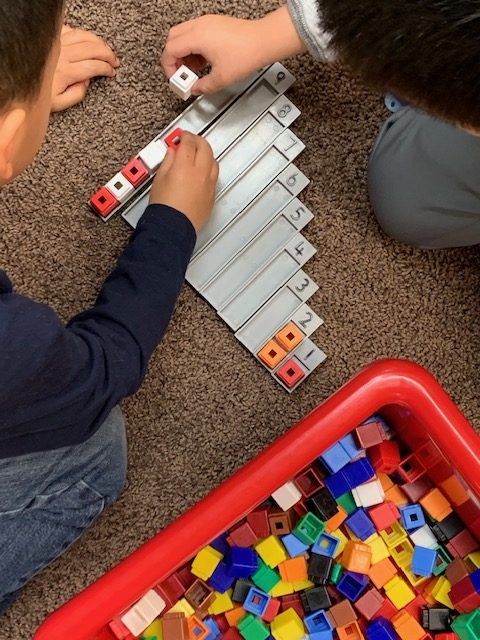 Child counting, measuring and doing patterns with uniblocks at Lessard Playschool preschool program
